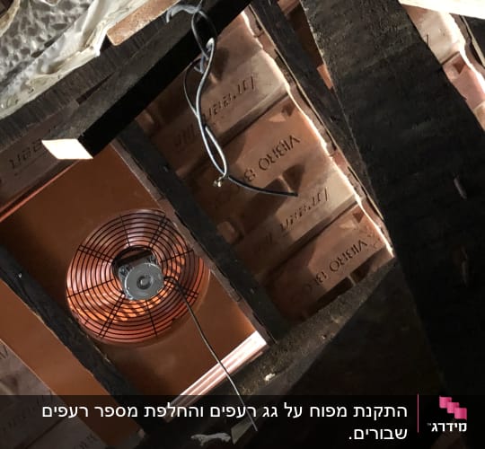 מאוורר מותקן בגג עם קורות עץ וחוטים